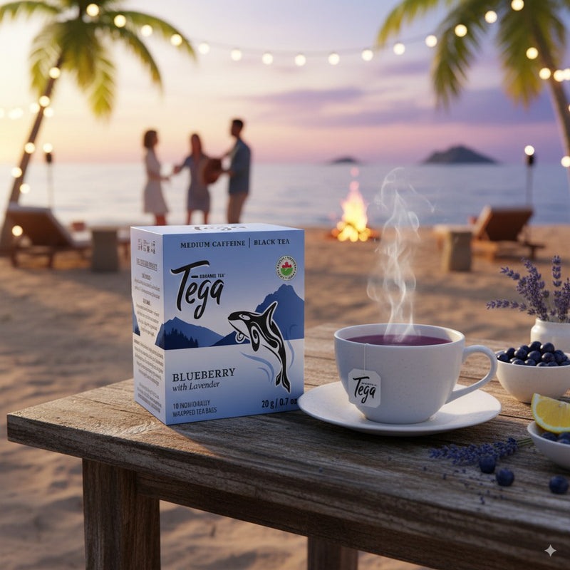 Tega Blueberry Black Tea set on a beach table with people and a campfire in the background