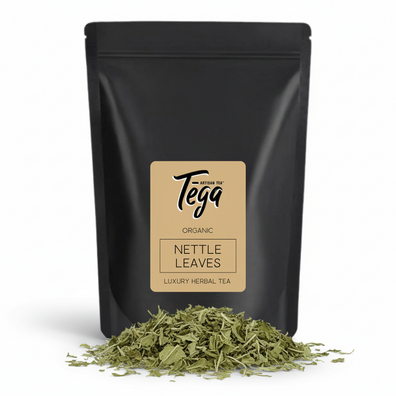 Black tea packaging with Tega label and dried nettle leaves on a white background